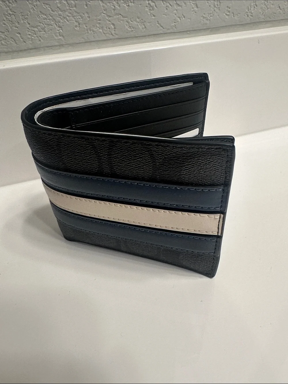 Coach Men's Black Signature Pattern Bifold Wallet with Blue and Cream Stripes